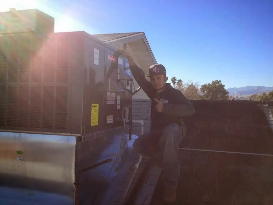 HVAC technician performing AC Tune-Up on a rooftop unit in Whitehall